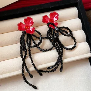 Elegant red flower stud earrings with long black beaded tassels and sparkling crystals