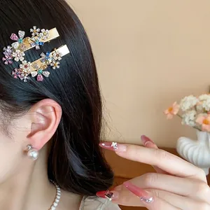 Elegant gold metal hair clips with sparkling colorful rhinestone flowers on a model
