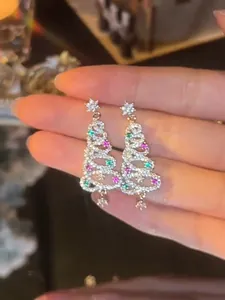 Close-up view of sparkling Christmas tree drop earrings with colorful zircons and star details