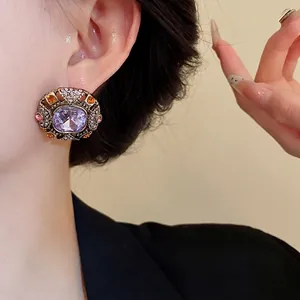 Vintage palace style earrings with large purple crystal and geometric rhinestone accents