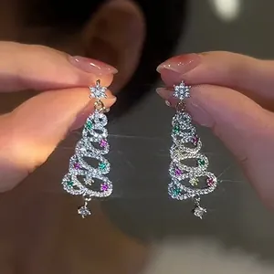 Detail view of sparkly Christmas tree earrings with colorful zircon stones.