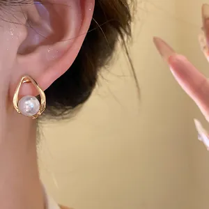Close-up of an elegant vintage French-style teardrop gold earring with a large pearl