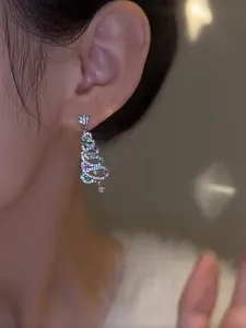 Close-up of a sparkling silver Christmas tree earring featuring colorful zircon stones