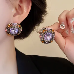 Close-up details of vintage court style stud earrings with purple crystals and rhinestones