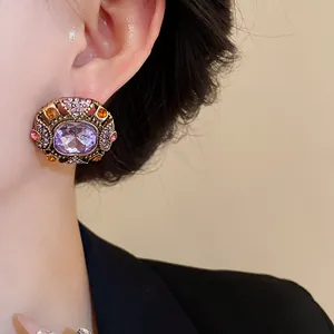 Close-up of vintage court style stud earring with purple crystal and rhinestones