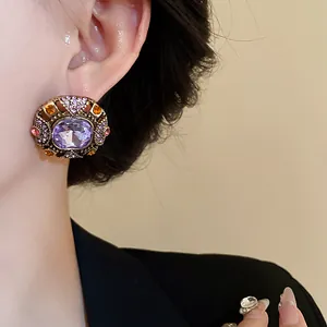 Detailed macro view of vintage court style earring featuring a large purple crystal stone