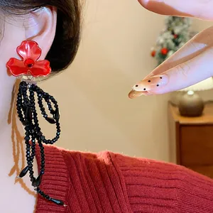 Elegant red flower stud earrings featuring long black beaded tassels for a chic look