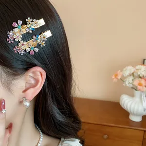 Close-up of elegant gold hair clips with colorful rhinestone flowers on a model