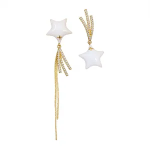 Asymmetrical 18k gold plated star earrings featuring zircons and elegant white accents.