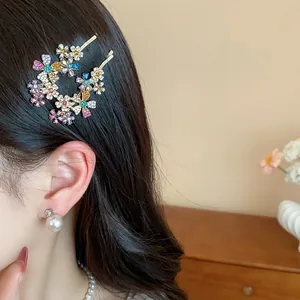 Macro close-up of sparkling metal rhinestone flower hair clips worn on dark wavy hair