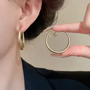 Dettaglio degli orecchini a clip a forma di C in oro opaco stile vintage per orecchi non forati
