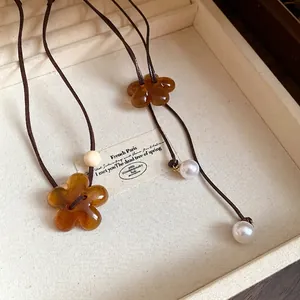 Vintage brown resin flower pendant necklace with pearls in a cream jewelry box