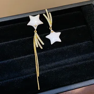 Detailed macro view of asymmetric star earrings featuring 18k gold plating and shiny zircon