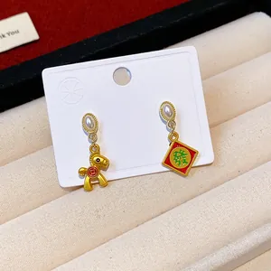 Close-up of festive red New Year earrings featuring a golden horse and Chinese fortune character