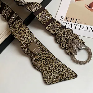 Cintura in pelle leopardata vintage con fibbia a farfalla in strass e catena a vita larga.