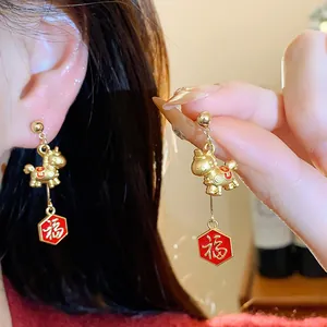 Macro view showing the gold horse design and red Fu character pendant of the earring.