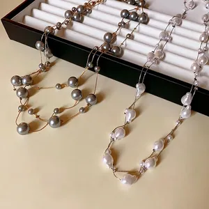 French style long necklace with minimalist white and grey faux pearls on gold chain.