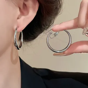 Dettaglio di orecchini a clip in argento a forma di C per chi non ha i lobi forati