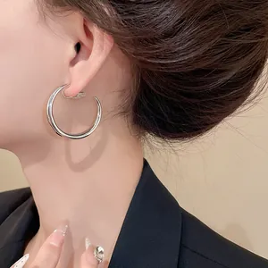 Dettaglio ravvicinato di un orecchino a clip a forma di C in argento su un modello reale