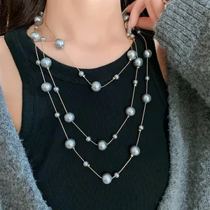 Elegant multi-layered long necklace with grey artificial pearls of varying sizes.