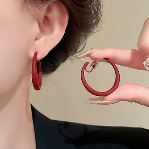 Vista dettagliata di orecchini a clip a forma di C rossi opachi senza buco orecchio