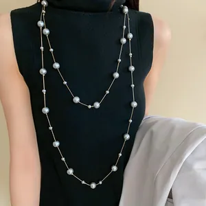 French style layered long faux pearl necklace shown on a black turtleneck sweater