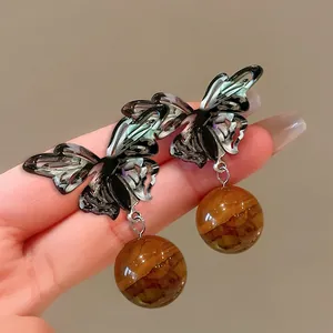 Exquisite detail of Maillard style butterfly earrings featuring natural tiger eye stones