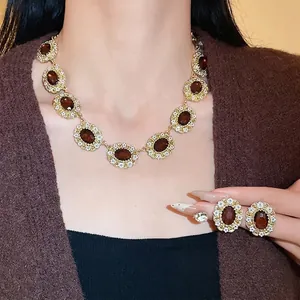 Vintage palace style necklace set with brown oval stones and white floral border details.