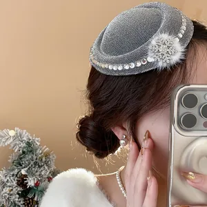 Detailansicht einer silbernen Haarklammer mit Strass-Schneeflocke und Fellball