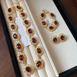 Vintage palace style jewelry set featuring red stones and white floral enamel details