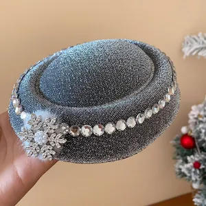 Nahaufnahme einer silbern glitzernden Hut-Haarklammer mit Strass-Schneeflocke und Fellball.