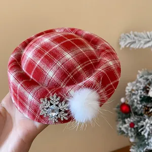 Nahaufnahme von roter karierter Hut-Haarspange mit Strass-Schneeflocke und Fellbommel