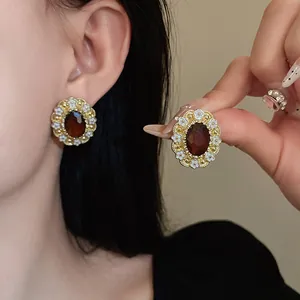 Vintage palace style oval earrings with brown gemstone and white enamel flowers.