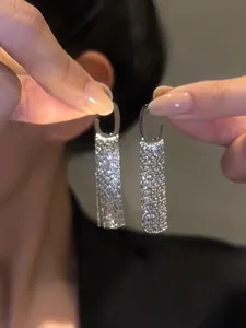 Detailed close-up showing the sparkling silver sequin texture of tassel earrings