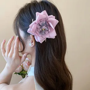 Große Haarklammer mit altrosa Stoffblume auf langem braunem Haar, seitliche Detailansicht.