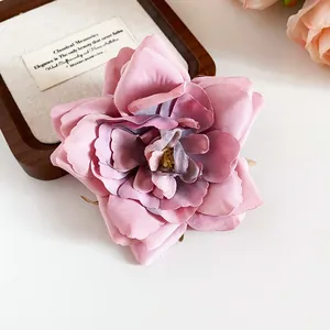 Elegante Makroaufnahme einer zartrosa Stoffblumen-Haarklammer auf einem Holzrahmen