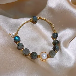 Detailed view of fashion bracelet featuring synthetic stones and pearls on silk