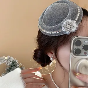 Detailansicht der silbernen Glitzer-Minihut-Haarklammer mit Strass-Schneeflocke und Pelz