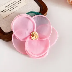 Detailansicht einer handgefertigten rosa Organza-Blumen-Haarklammer mit Blüten
