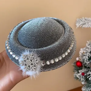 Detailansicht einer silbernen Glitzer-Mini-Barett-Haarspange mit Strass-Schneeflocke und Pelzball