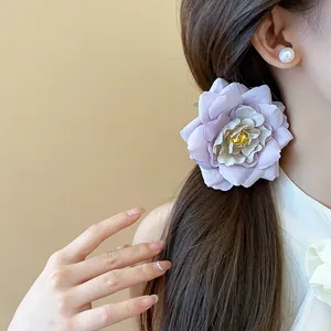 Detaillierte Makroaufnahme einer violetten Stoffblumen-Haarspange im dunklen Haar
