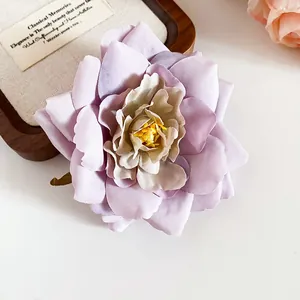 Nahaufnahme einer violetten Stoffblumen-Haarklammer mit Lagen