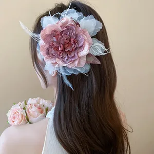 Detaillierte Nahaufnahme einer eleganten Stoffblumen-Haarklammer auf braunem Haar