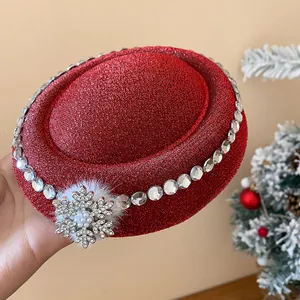 Nahaufnahme eines roten Glitzer-Haar-Fascinators mit Schneeflocken-Details