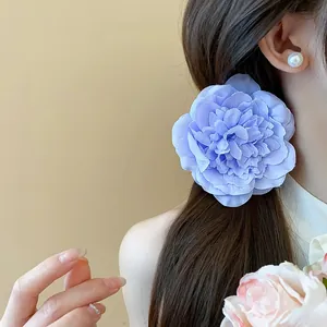 Detailansicht einer eleganten hellblauen Stoffblumen-Haarspange an einem Modell