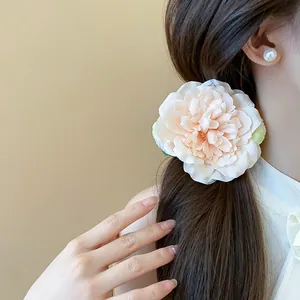 Nahaufnahme einer süßen pfirsichfarbenen Stoffblumen-Haarspange in langem Haar