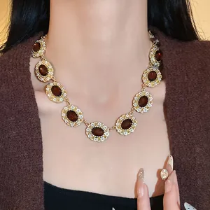 Close-up view of vintage gold necklace with amber oval stones and floral details