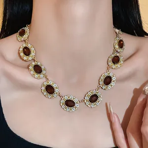 Detailed view of a vintage court style necklace with oval amber gemstones and white flowers