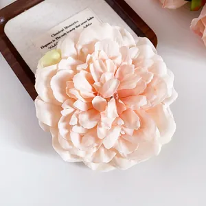 Elegante Nahaufnahme einer großen pfirsichfarbenen Stoffblumen-Haarklammer mit Blüten