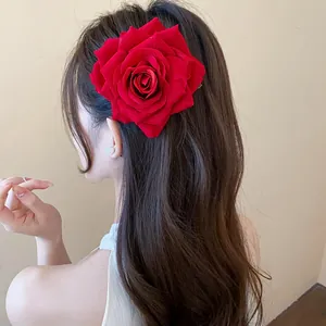 Detailansicht einer eleganten großen roten Stoffrosen-Haarspange an einem Modell.